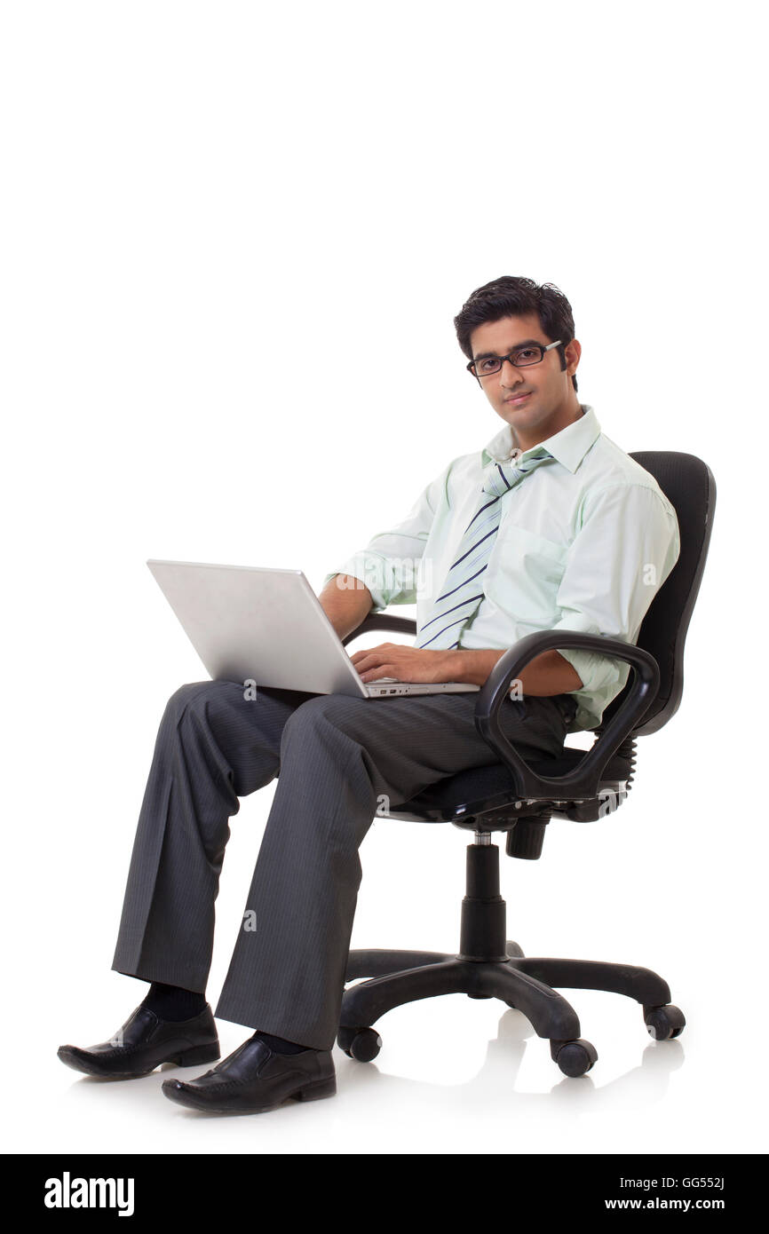 Felice giovane impreditore sulla sedia utilizzando laptop Foto Stock