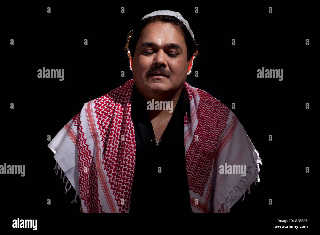 Uomo islamico pregando su sfondo nero Foto Stock