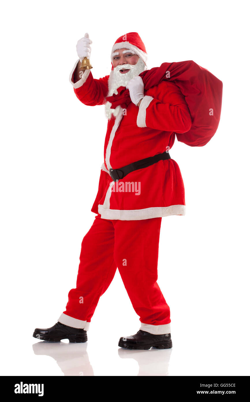 Lunghezza completa di Babbo Natale che trasportano il sacco di presenta con campana Foto Stock