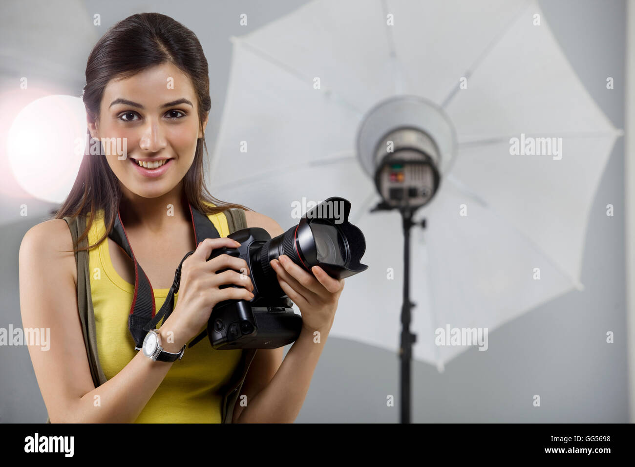 Ritratto di giovane donna fotografo con fotocamera digitale in studio Foto Stock