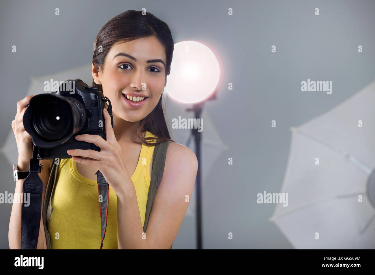 Ritratto di giovane donna fotografo con fotocamera digitale in studio Foto Stock
