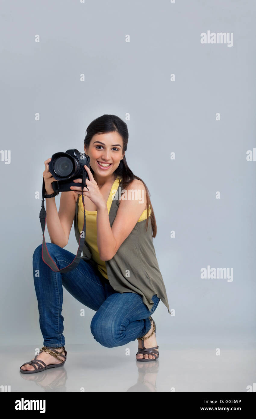 Ritratto di donna sorridente fotografo con fotocamera nel suo studio Foto Stock