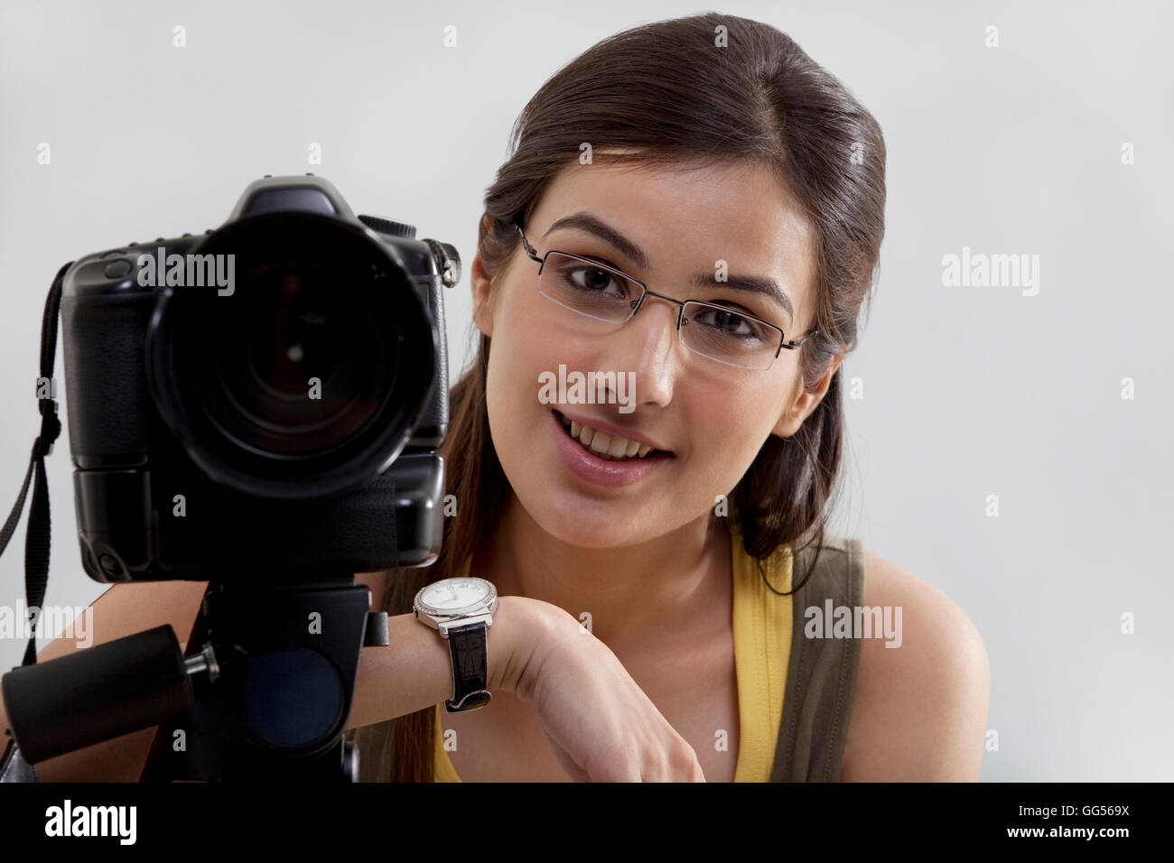Ritratto di un sorridente giovane donna con fotocamera digitale Foto Stock