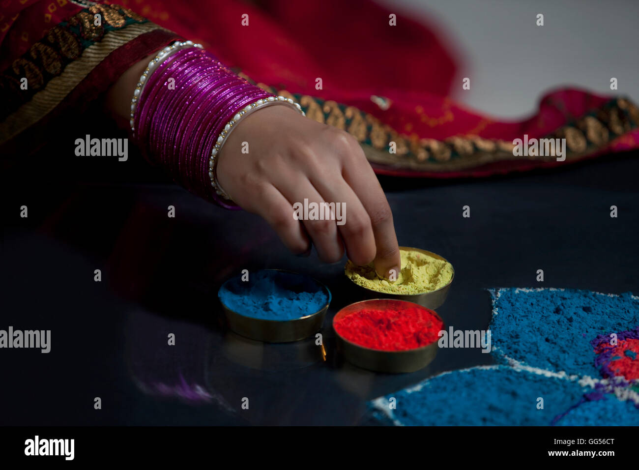 Close-up di donna con mano schiave rendendo rangoli Foto Stock