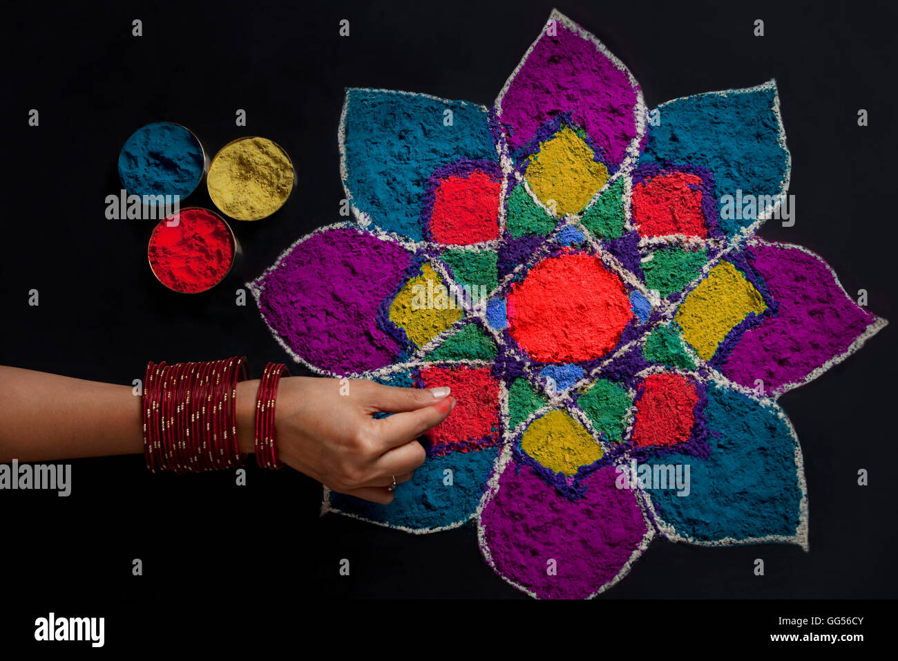 Elevato angolo di visione della donna di mano rendendo rangoli Foto Stock