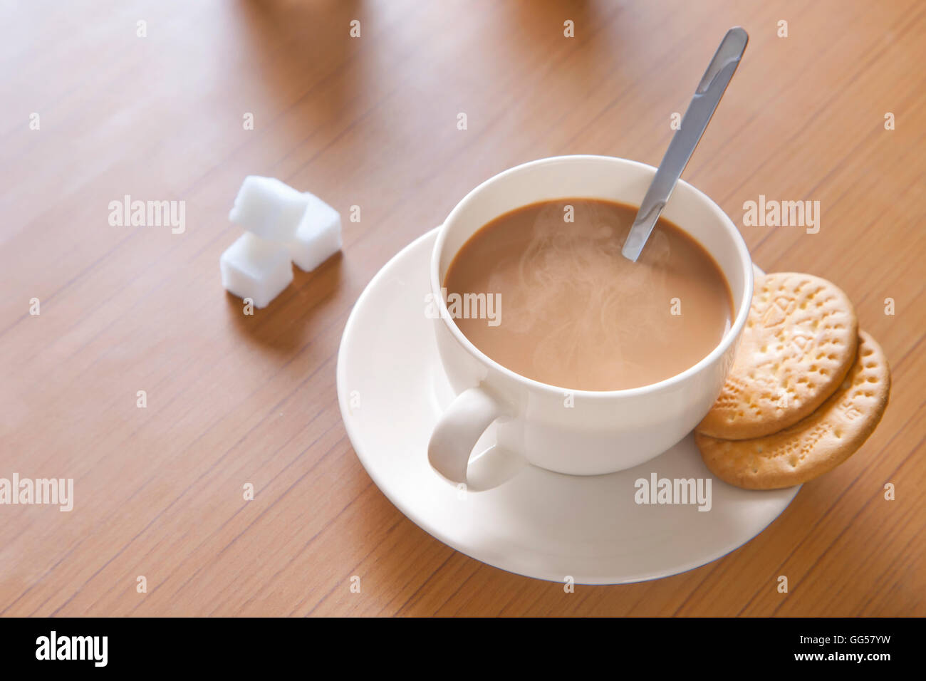 Close-up di tè caldo, cubetti di zucchero e biscotti sul tavolo Foto Stock