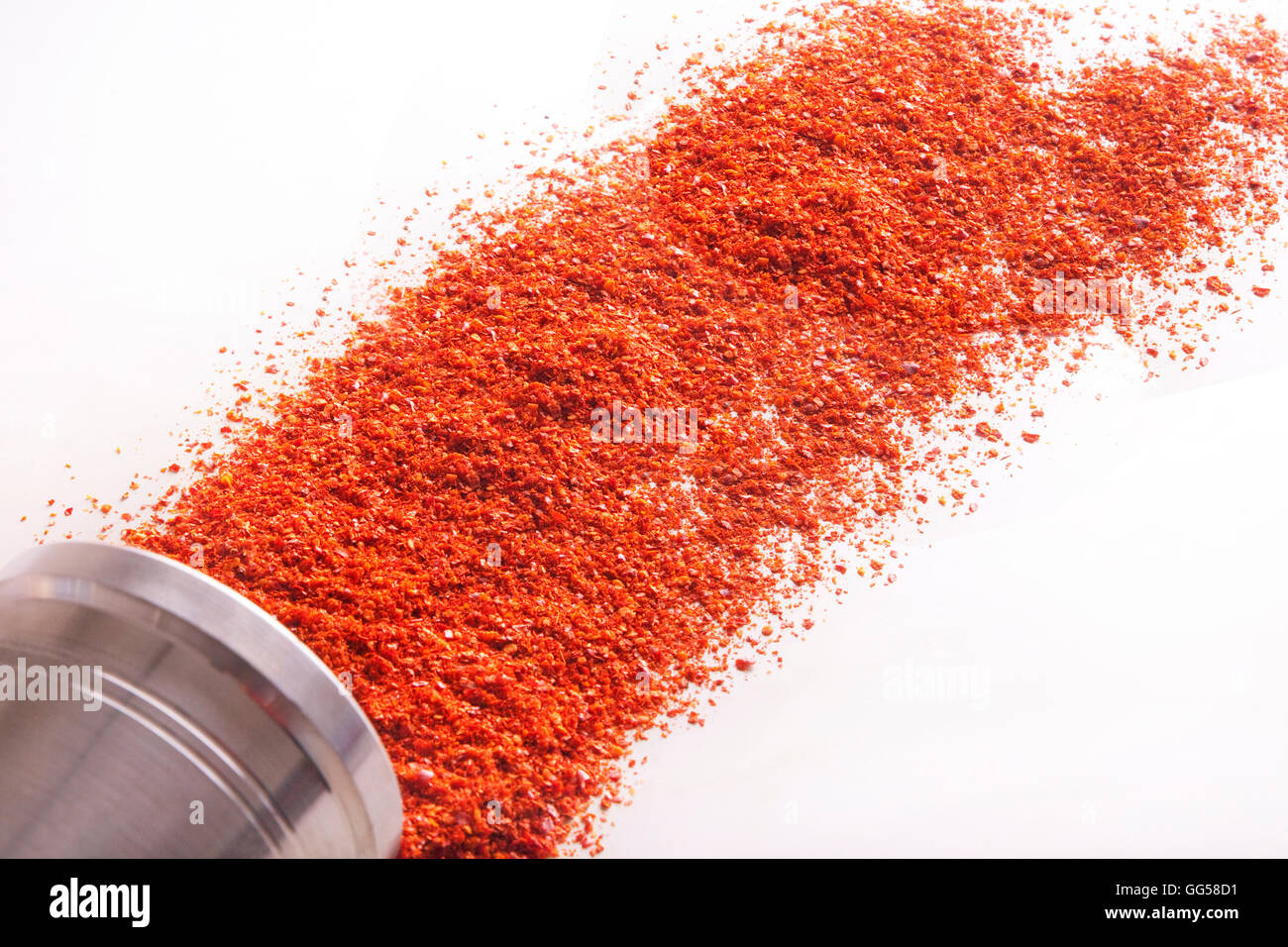 Peperoncino rosso in polvere distribuito su sfondo bianco Foto Stock