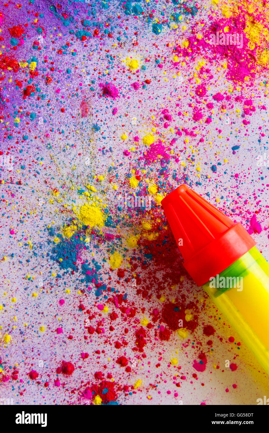 Squirt gun su colorati di vernice in polvere distribuito su sfondo bianco Foto Stock