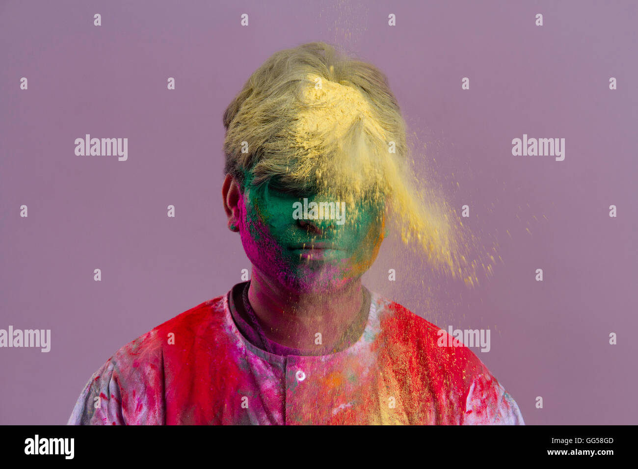 L'uomo celebra Holi festival con vernici in polvere su sfondo colorato Foto Stock