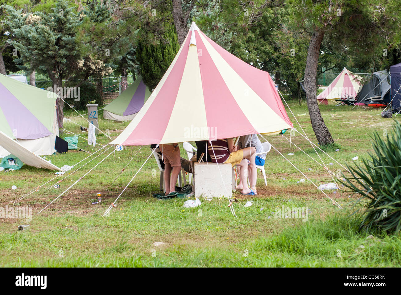 Persone che si nascondono da Pioggia sotto una tenda. Il festival di musica  campeggio Foto stock - Alamy