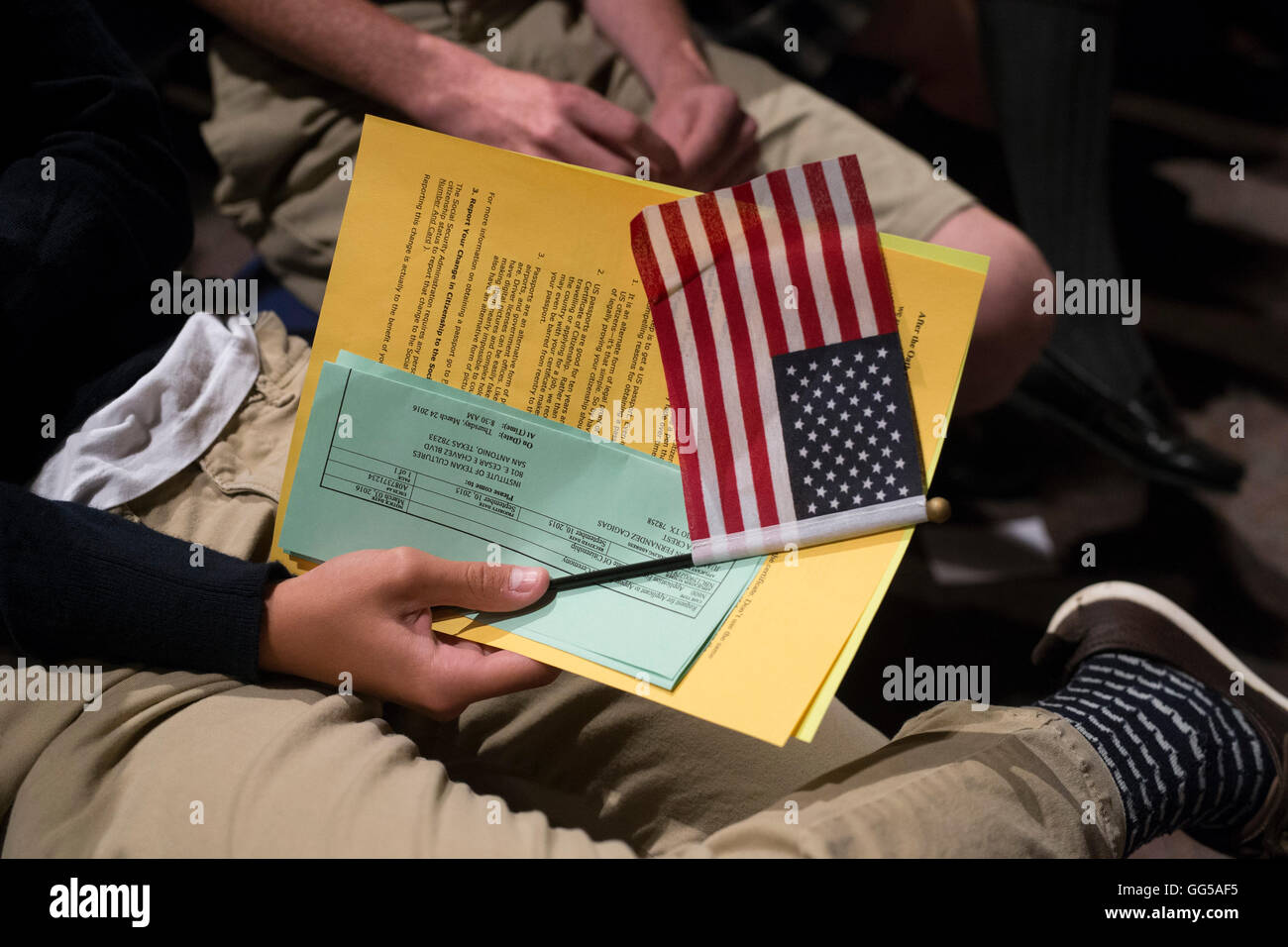Nuovo cittadino degli Stati Uniti detiene piccola bandiera americana durante il giuramento in occasione della cerimonia in San Antonio, Texas Foto Stock