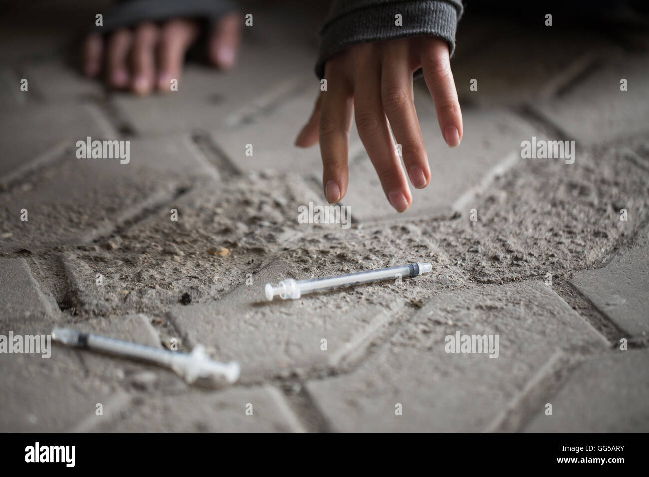 Close up addict donna mani e siringhe di farmaco Foto Stock