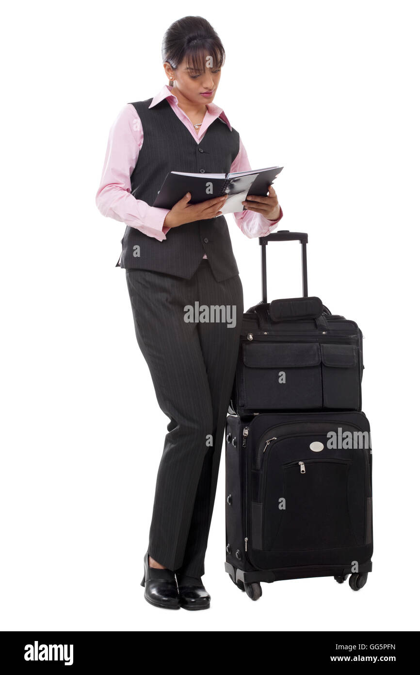Per tutta la lunghezza della bella imprenditrice con bagagli libro di lettura Foto Stock