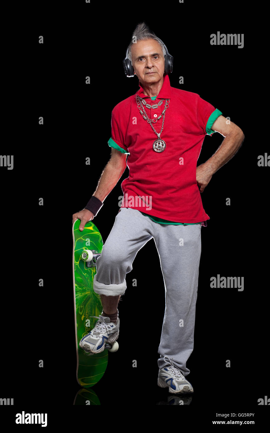 A piena lunghezza Ritratto di uomo anziano con lo skateboard Foto Stock