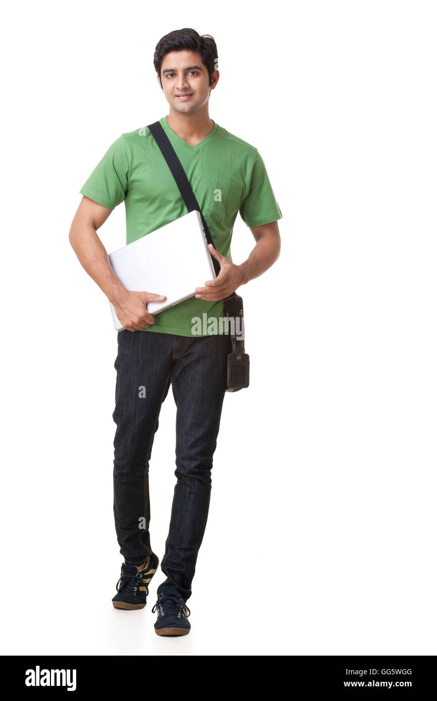 Lunghezza completa di studente di college con il computer portatile si cammina su sfondo bianco Foto Stock