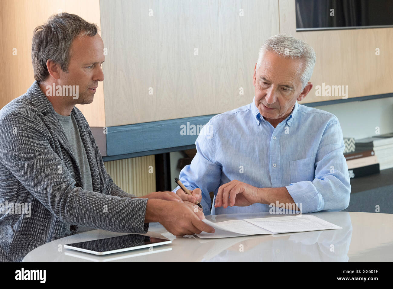 Senior uomo facendo la documentazione con il consulente finanziario a casa Foto Stock