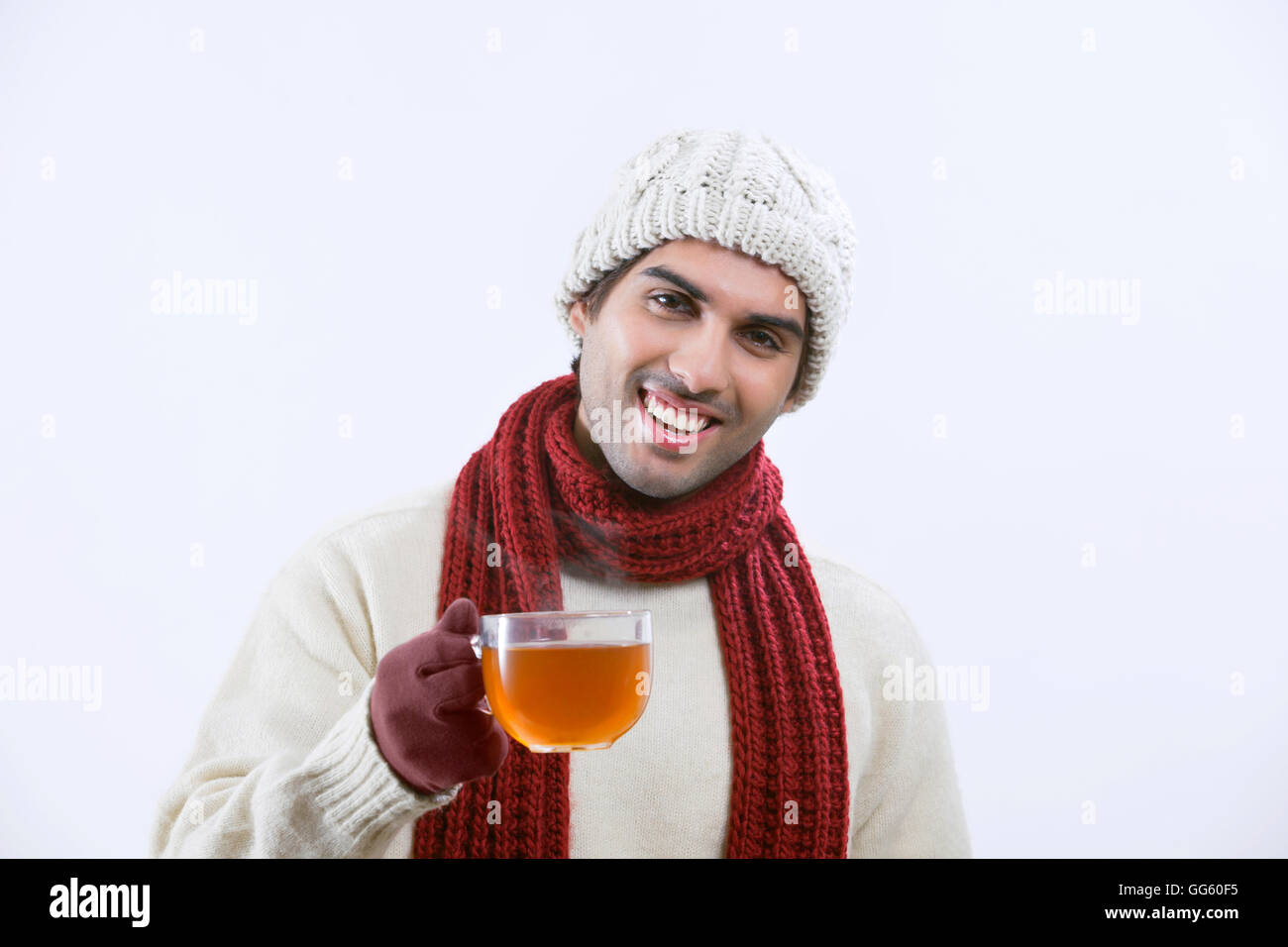 Felice giovane uomo di bere il tè nero su sfondo bianco Foto Stock