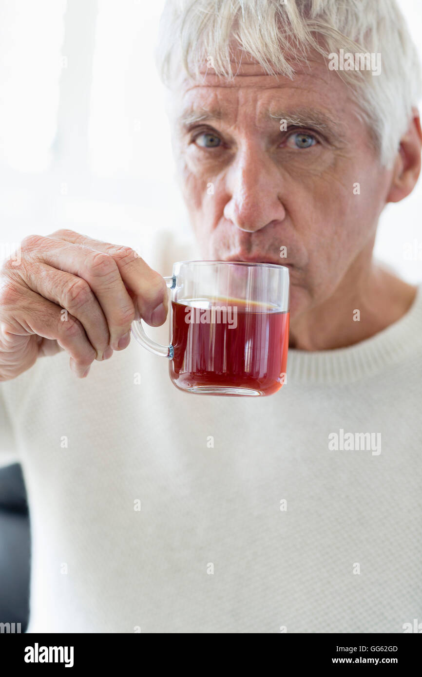 Senior uomo godendo di tazza di tè verde Foto Stock