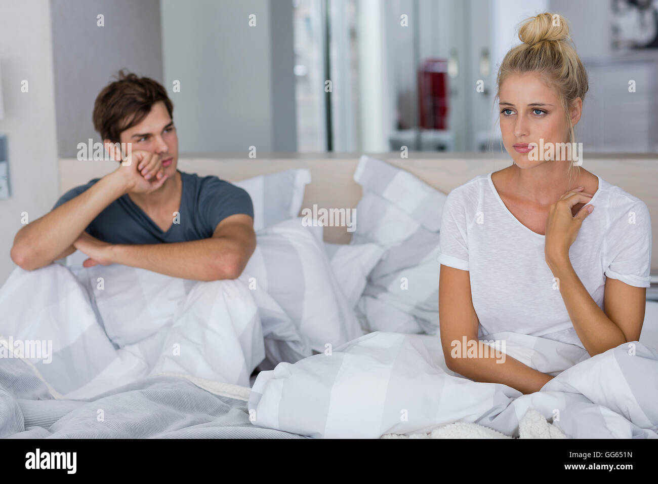Coppia giovane seduto sul letto con difficoltà di relazione Foto Stock
