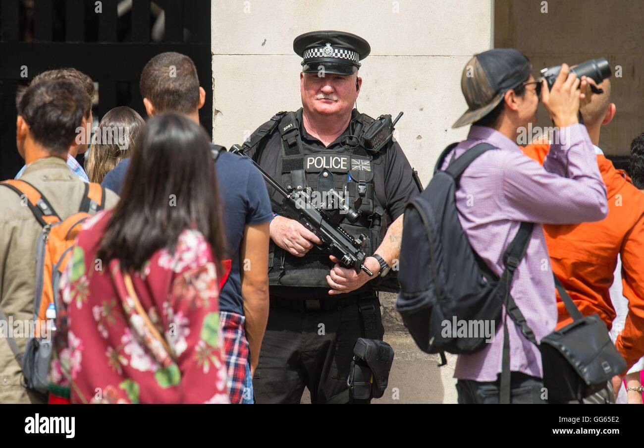 Un agente di polizia armato sul dovere nel centro di Londra, come Scotland Yard ha annunciato che il primo di 600 ulteriori ufficiali armati sono stati addestrati e operativamente pronto e ha svelato i piani per mettere più tiratori sul servizio pubblico di pattuglia. Foto Stock