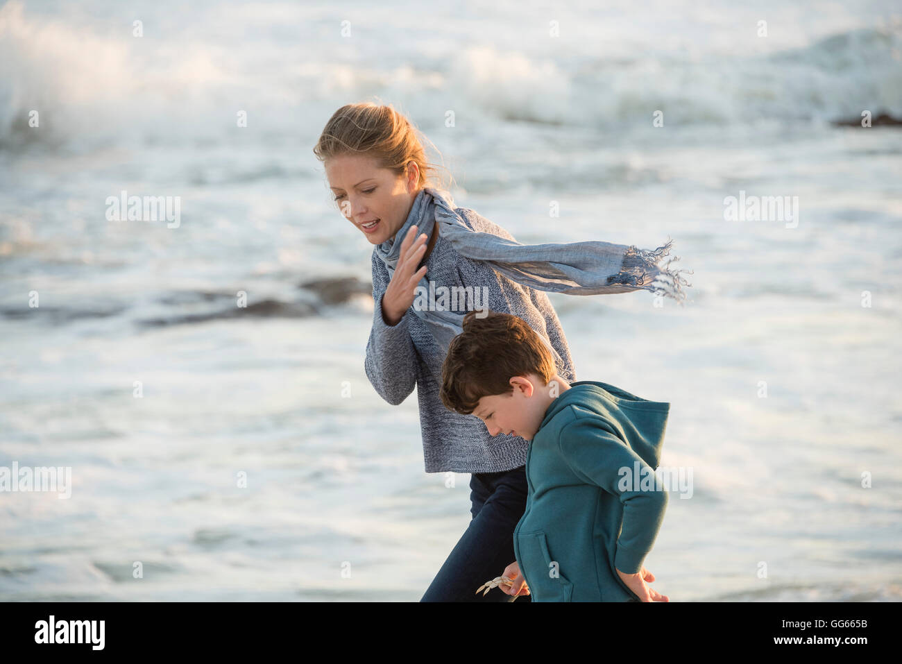 Felice madre e figlio di camminare sulla spiaggia Foto Stock