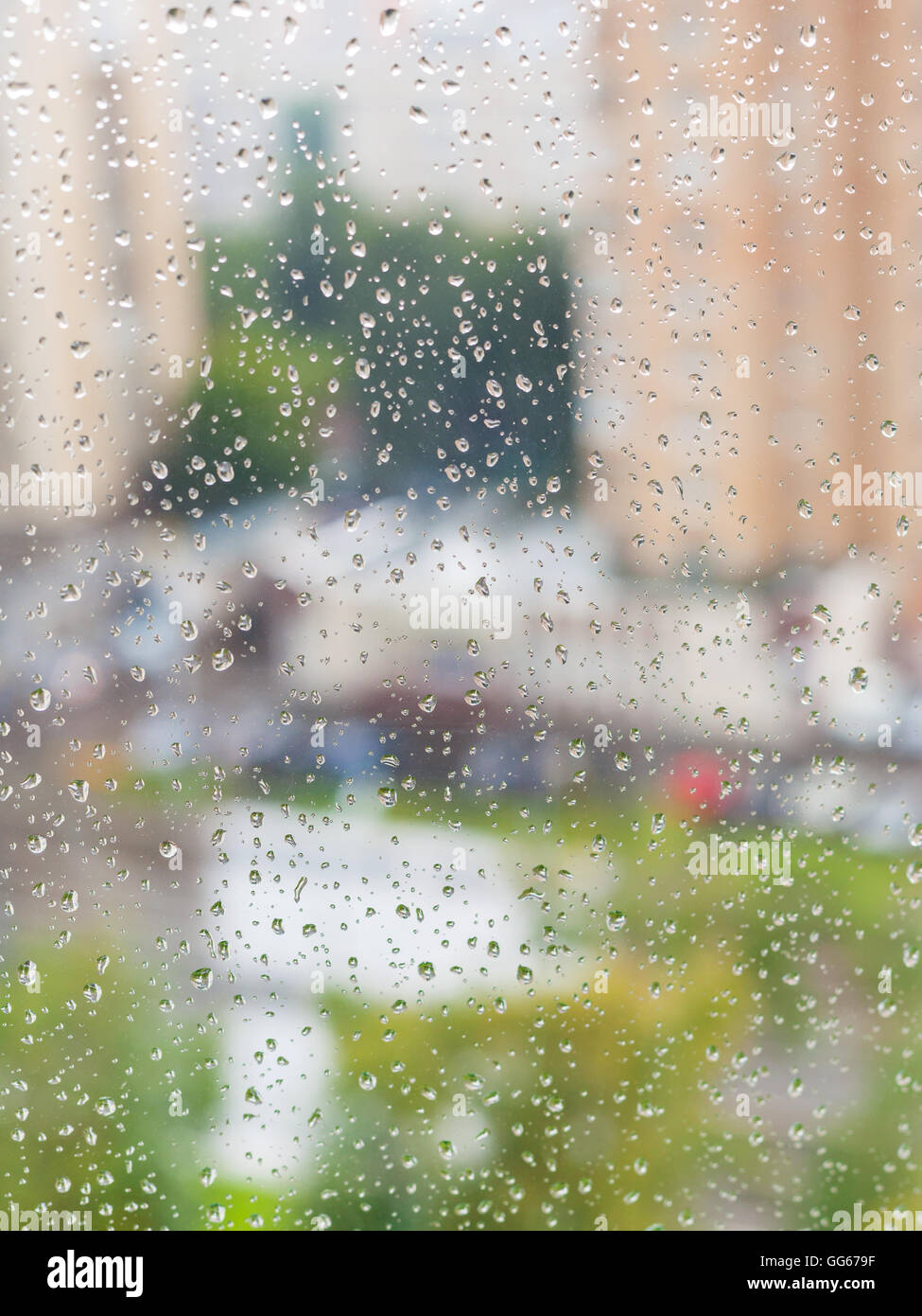 Le gocce di pioggia sulla finestra e sfocata cityscape sullo sfondo Foto Stock