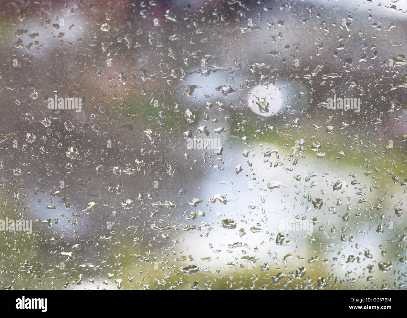 Gocce di pioggia sul vetro di finestra e sfocata background urbano Foto Stock