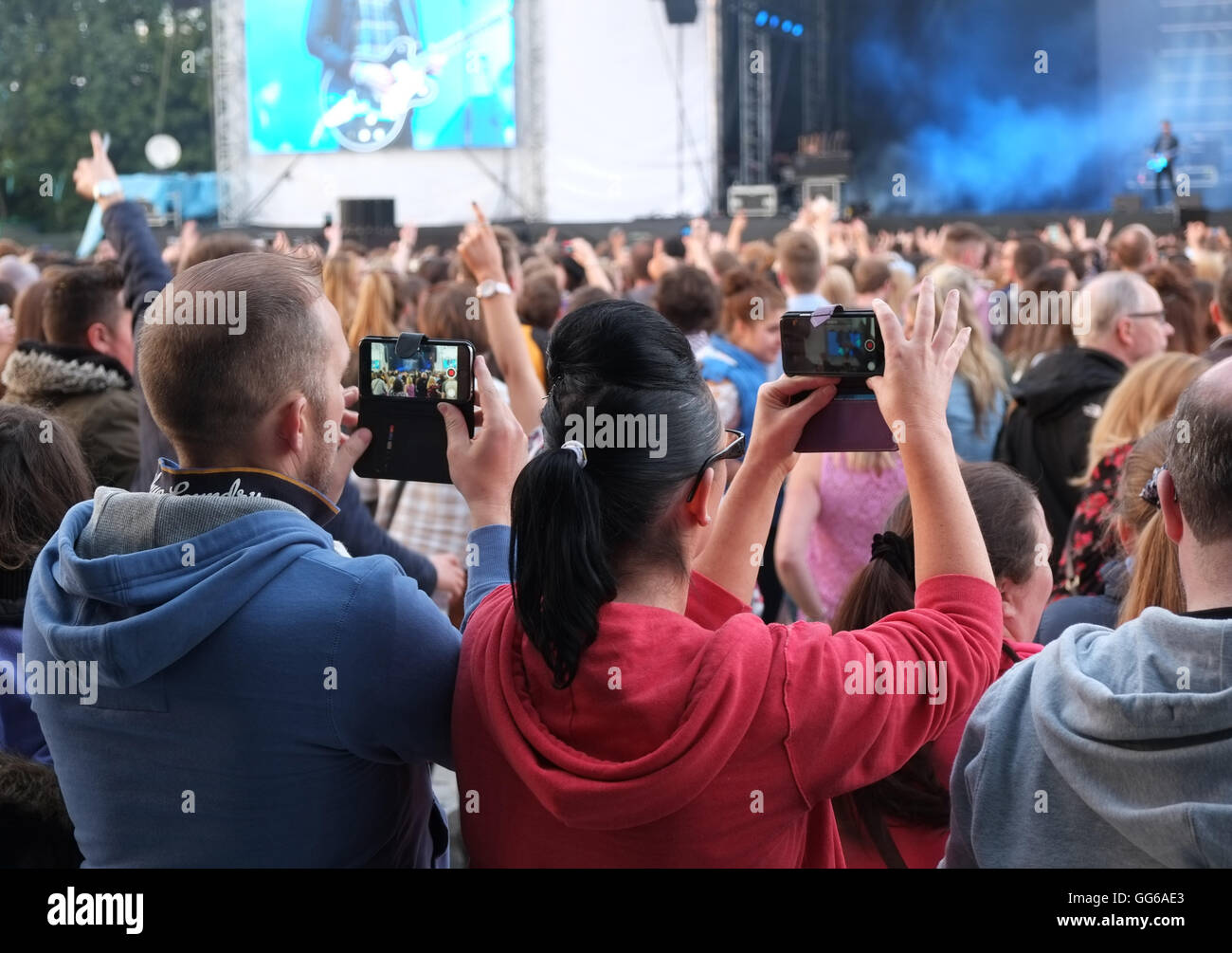 Giovane fare video sui loro telefoni, Tennents vitale, Boucher Road, Belfast,pubblico, Foto Stock