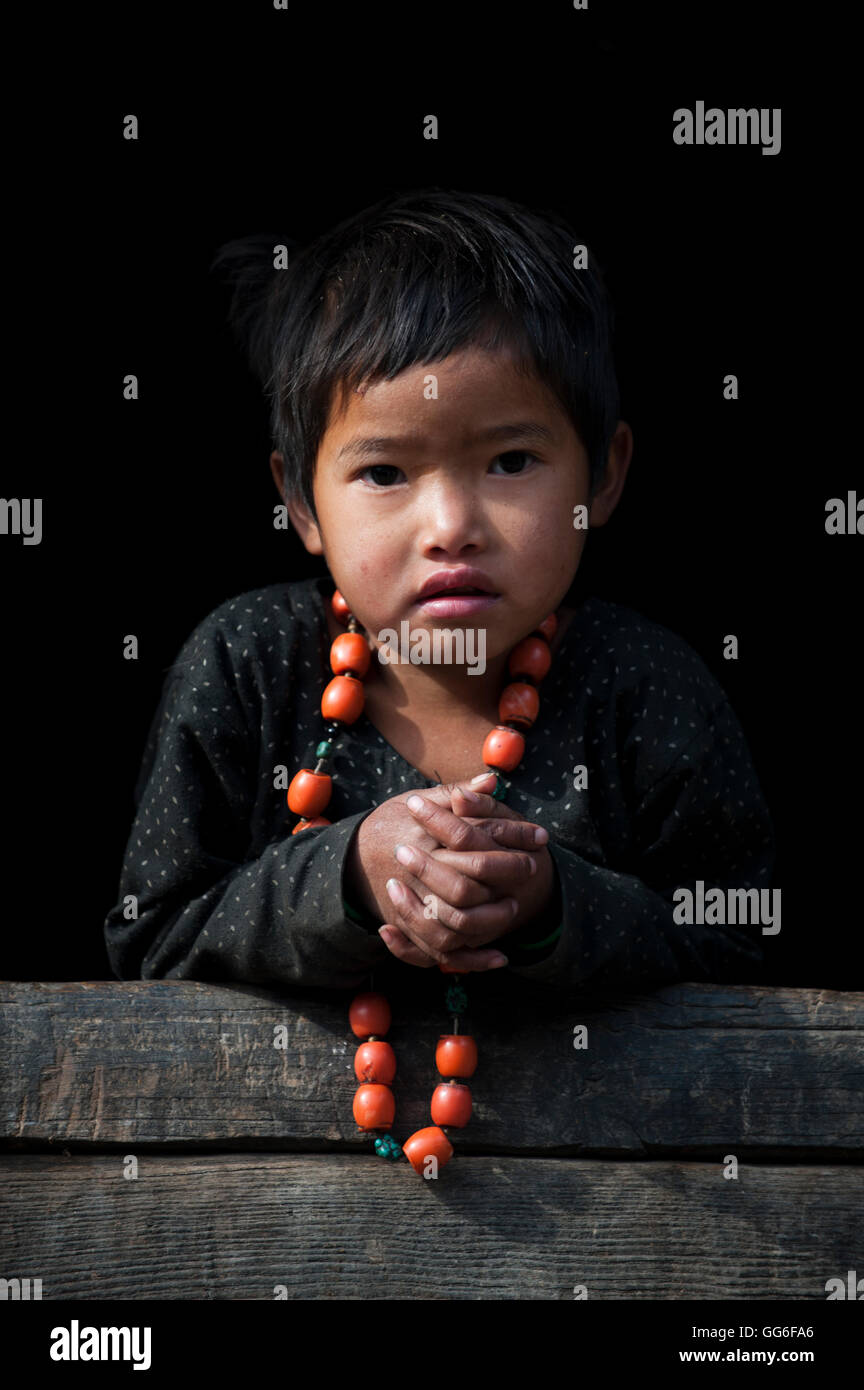 Una bambina gioca con la sua collana nella regione di Manaslu del Nepal, Asia Foto Stock