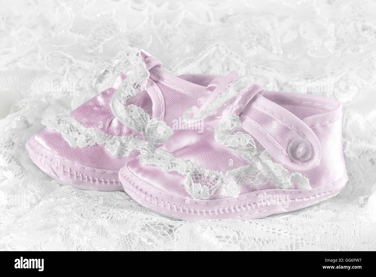 Rosa scarpine per bambini su un sfondo di pizzo Foto Stock