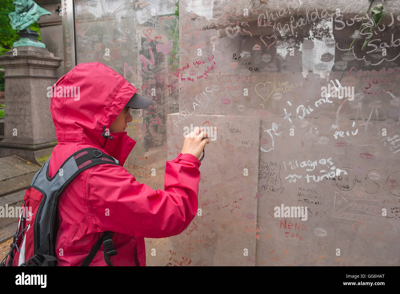 Pere Lachaise, un giovane turista fotografie graffiti sullo schermo in perspex intorno alla tomba di Oscar Wilde nel cimitero di Pere Lachaise, Parigi, Francia Foto Stock