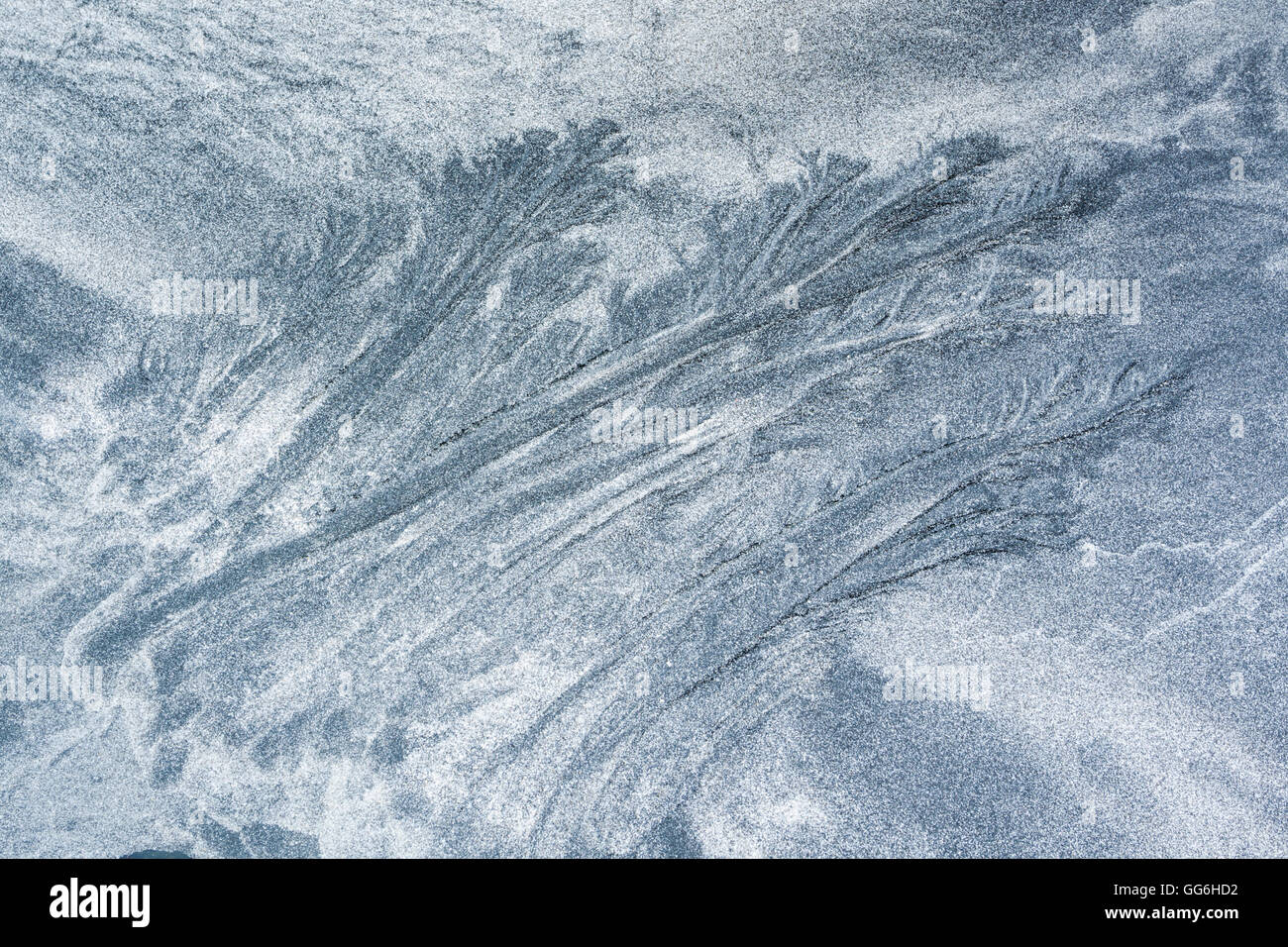Configurazioni formate dai movimenti di marea di sabbia nera vulcanica e cristallizzato bianco conchiglie di mare a Talisker Bay, Isola di Skye in Scozia Foto Stock