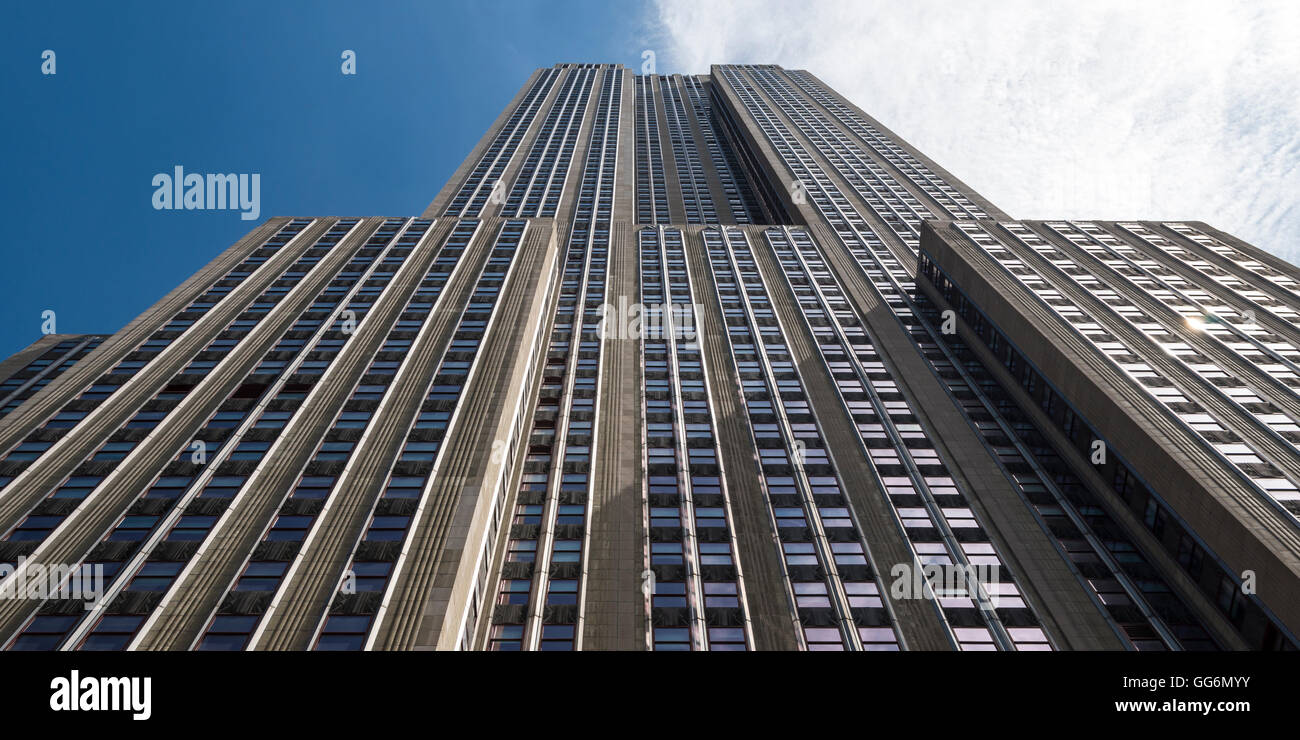 Vista guardando verso l'alto all'art deco Empire State Building di New York STATI UNITI D'AMERICA verso il cielo blu e nuvole bianche Foto Stock
