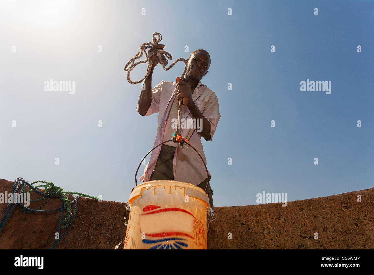 L'uomo il recupero di acqua da un pozzo nella regione del Sahel del fiume Senegal, Senegal Foto Stock