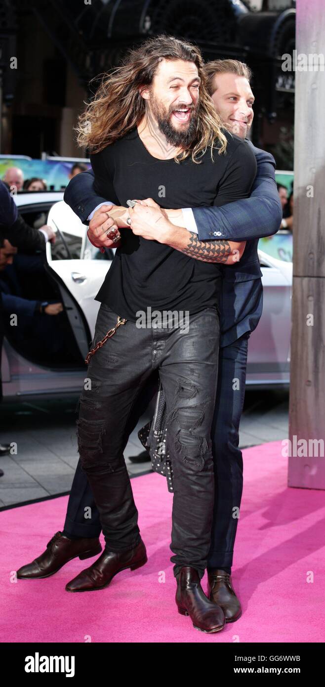 Jason Momoa è abbracciato da Jai Courtney durante la premiere europeo della squadra suicida a l'Odeon nel quadrato di Leicester, Londra. Foto Stock