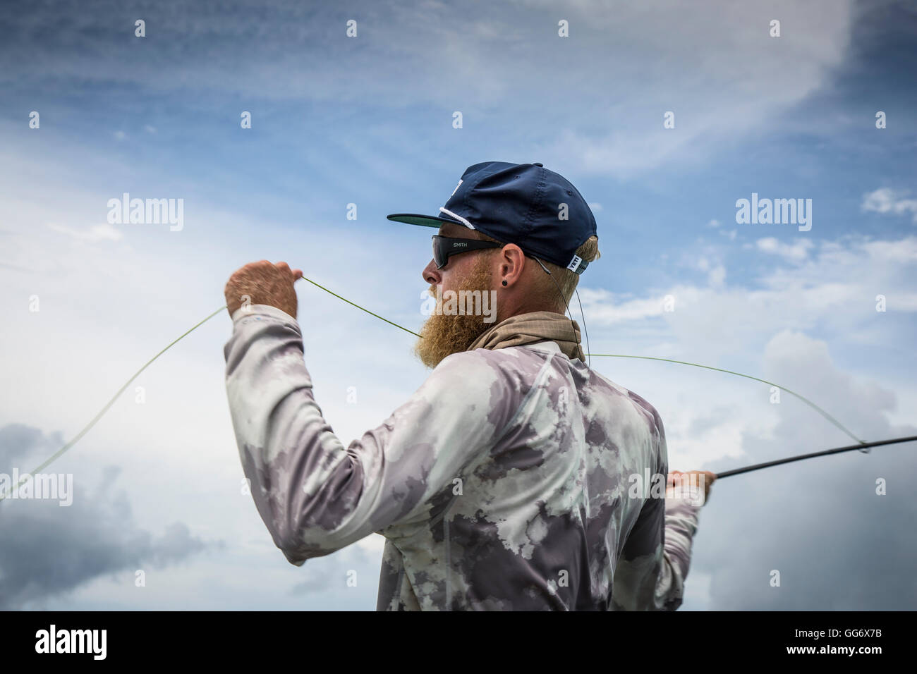 Il pescatore Jonathan Jones getta mentre la pesca nei tropici di Samoa. Foto Stock