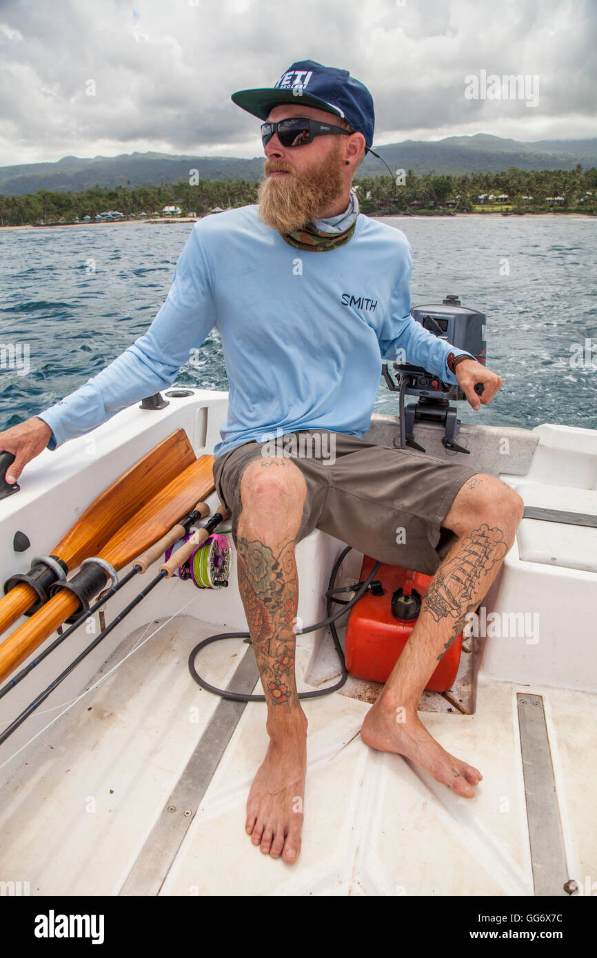 Jonathan Jones dirige una piccola barca in surf off Samoa mentre cerca di acque sfruttabili. Foto Stock