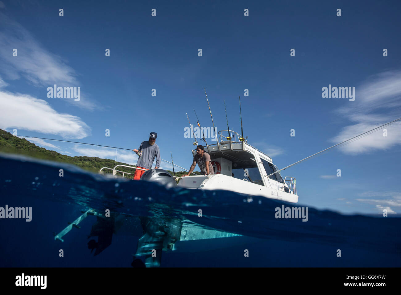 Il pescatore Jonathan Jones e Aidi fly fish fuori da una barca off shore di Samoa. Foto Stock