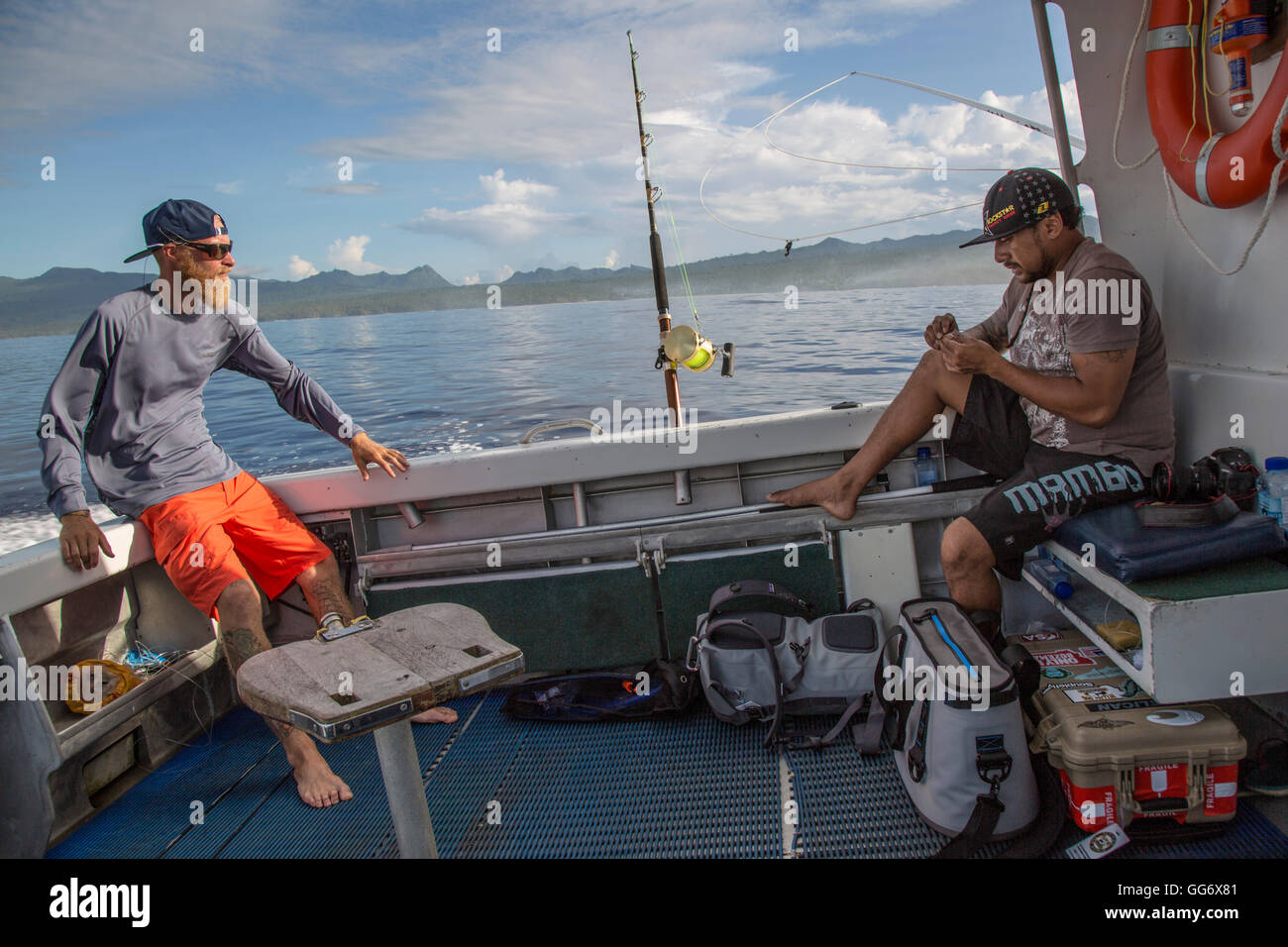 Il pescatore Jonathan Jones e Aidi resto sulla barca mentre si sposta in un nuovo luogo di pesca mentre la pesca al largo della costa di Samoa. Foto Stock