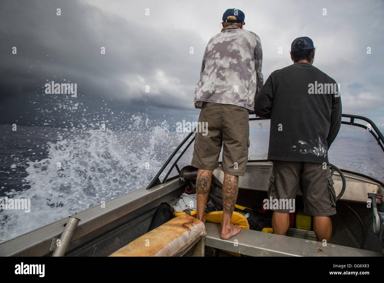 Il pescatore Jonathan Jones e Fatu, un locale di Samoa, provare a però superarsi un imminente tempesta mentre la pesca al largo della costa di Samoa. Foto Stock