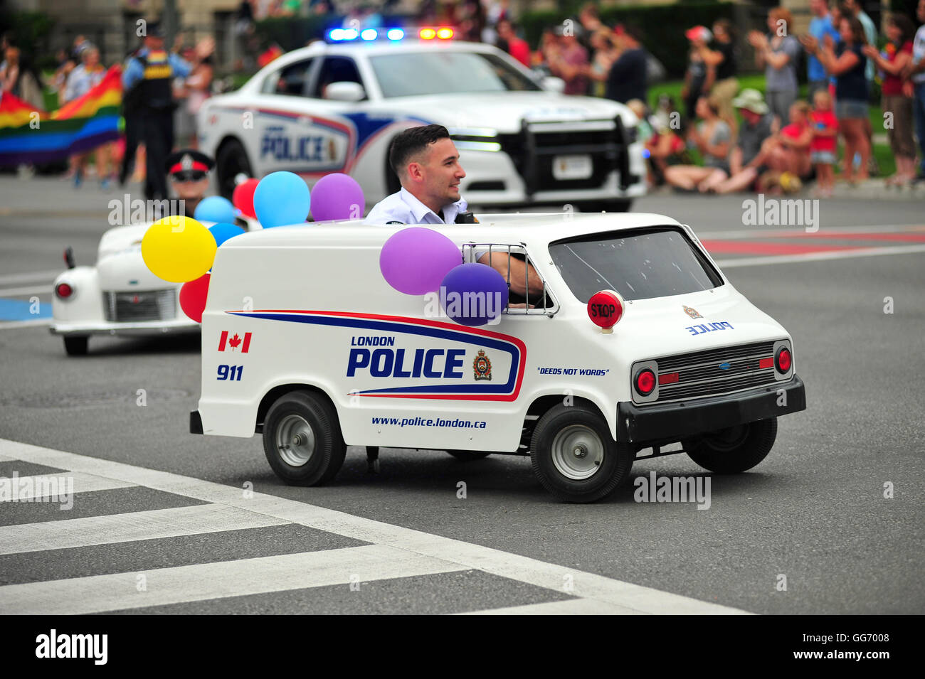 Un uomo alla guida di una polizia in miniatura van all annuale London, Ontario Pride Parade in Canada. Foto Stock
