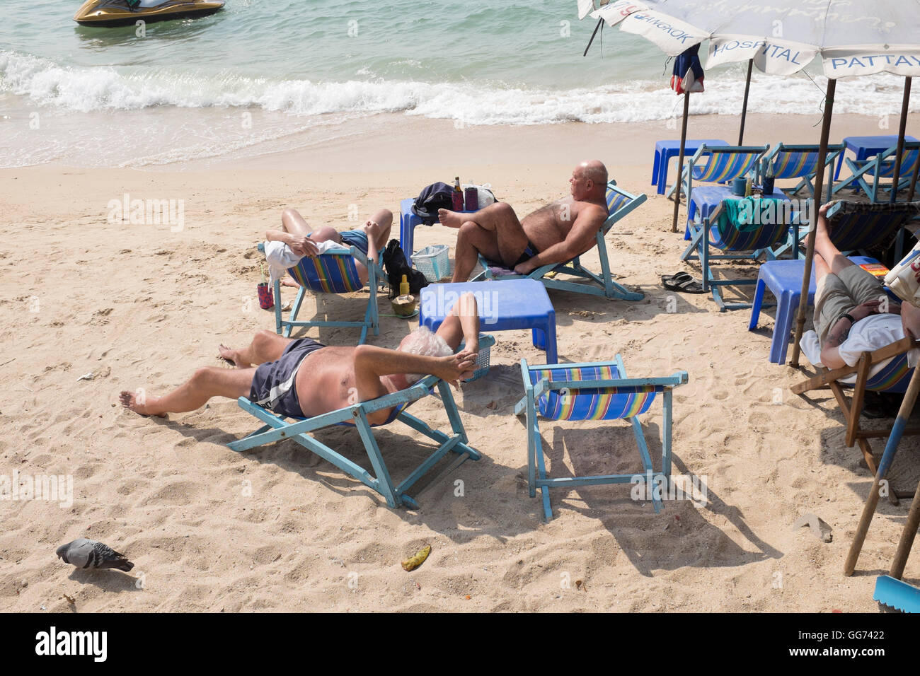 Western gli uomini a prendere il sole sulla spiaggia di Pattaya Thailandia Foto Stock