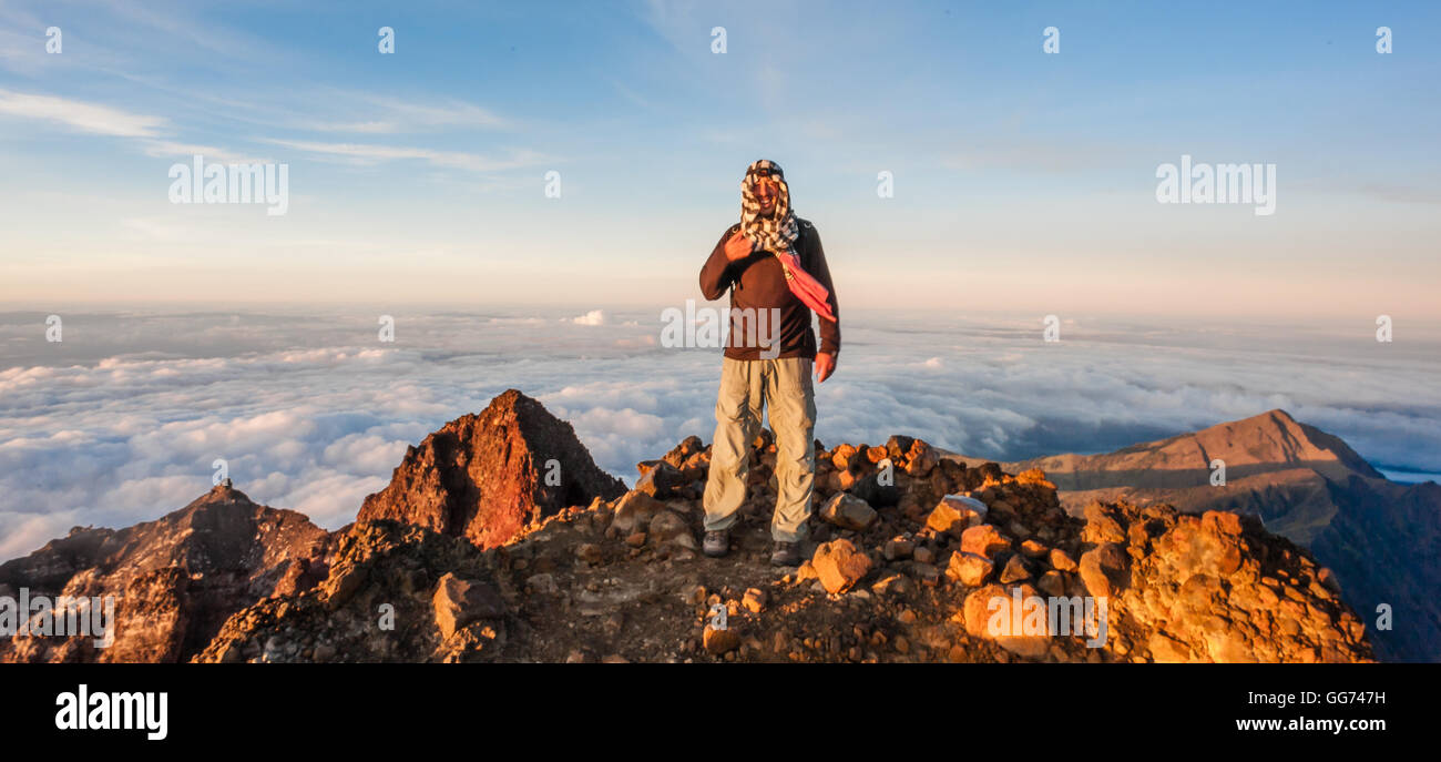 Uomo sulla sommità del monte Rinjani all'alba Foto Stock
