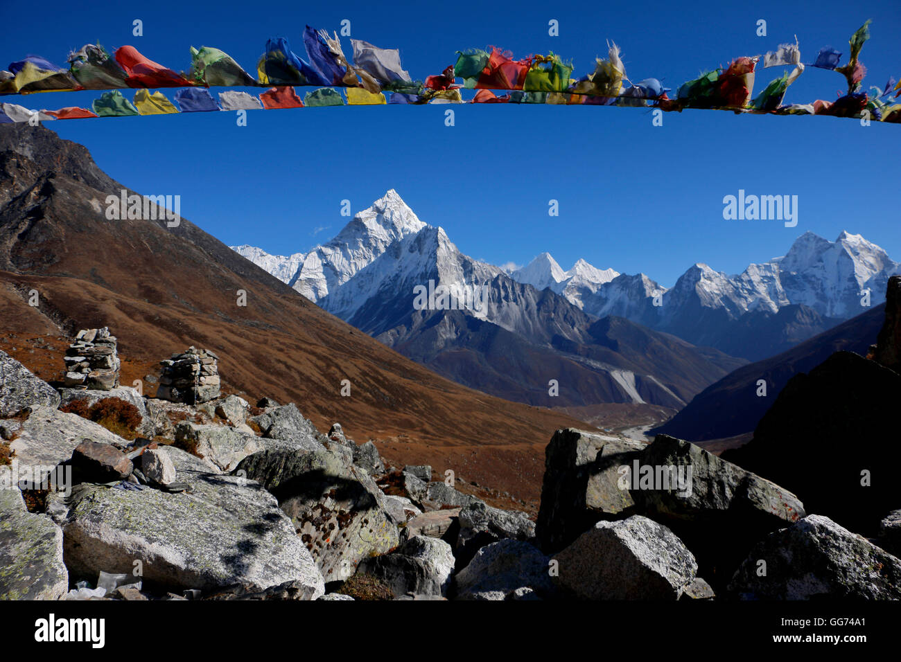 Bandiera di preghiera contro il fondale di Ama Damblam & Kangtega, a Thokia Pass, Lapide memoriale ai caduti gli alpinisti e gli sherpa Foto Stock