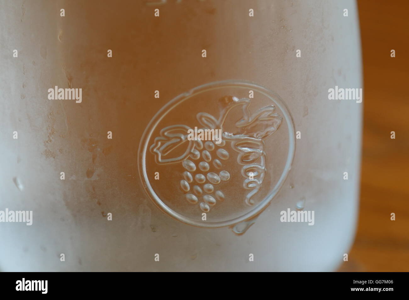 Simbolo di uve su una vite su un bicchiere di vino Foto Stock