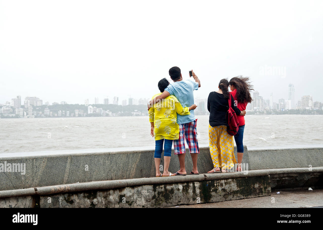 L'immagine di turistica prendendo selfie al Marine Drive faccia mare in monsone, a Mumbai, India Foto Stock