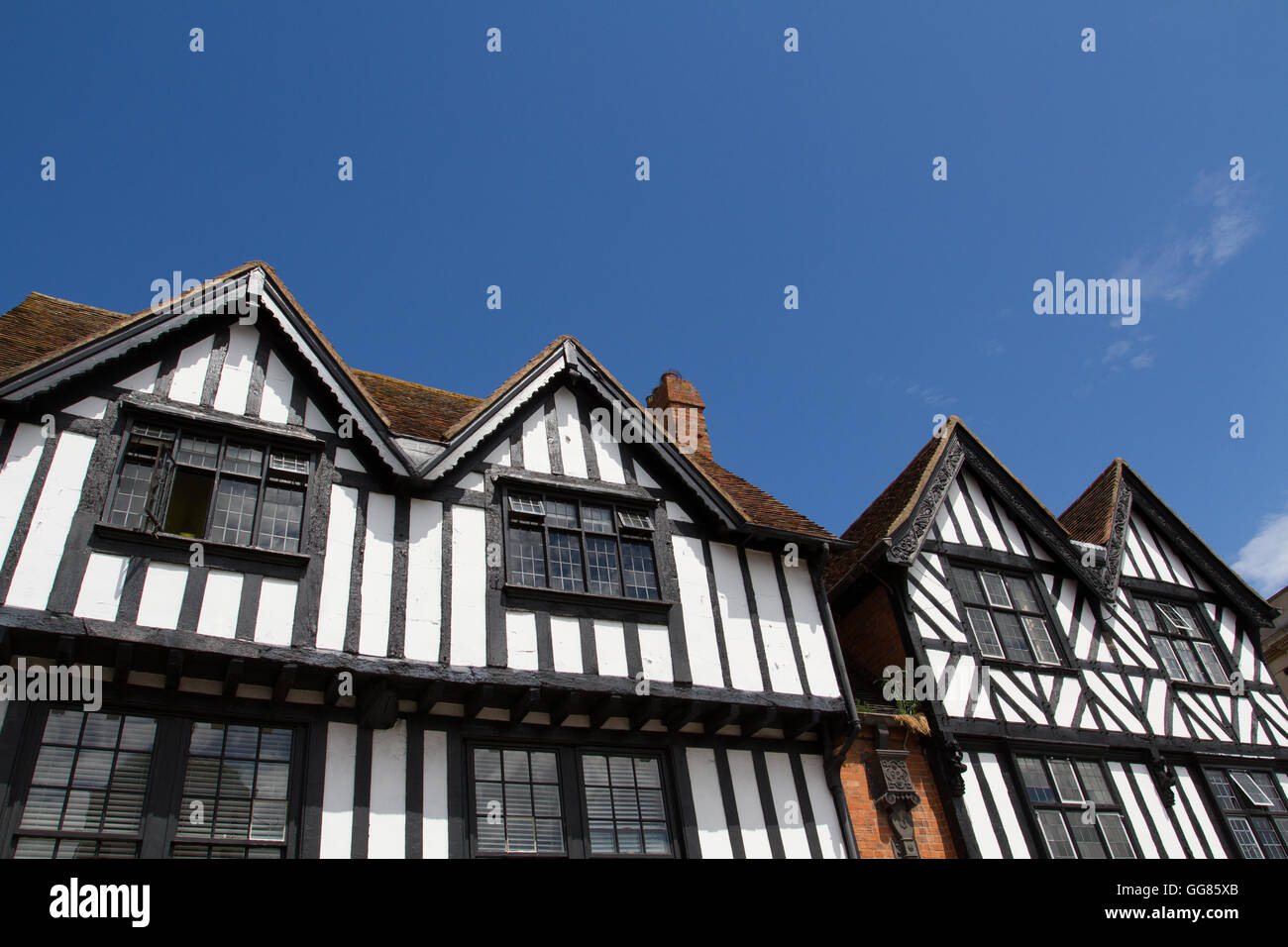 Una fila di stile tudor case in Inghilterra con i tradizionali in bianco e nero di facciate sotto un cielo azzurro. Foto Stock