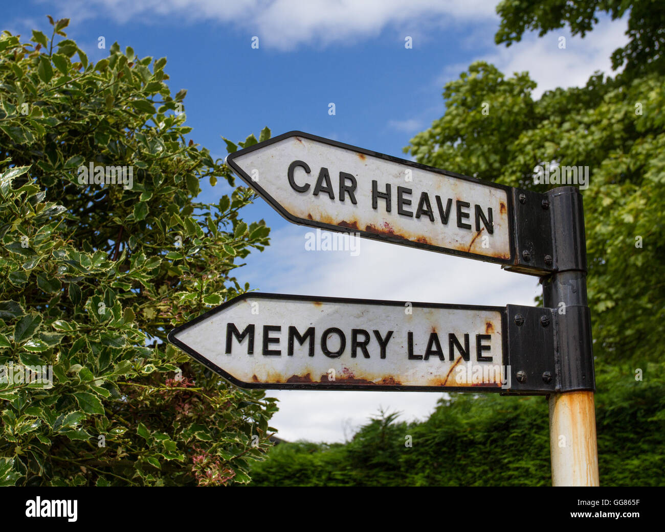 Un arrugginito, old road sign in campagna che indica la via verso il cielo per auto e memory lane. Foto Stock