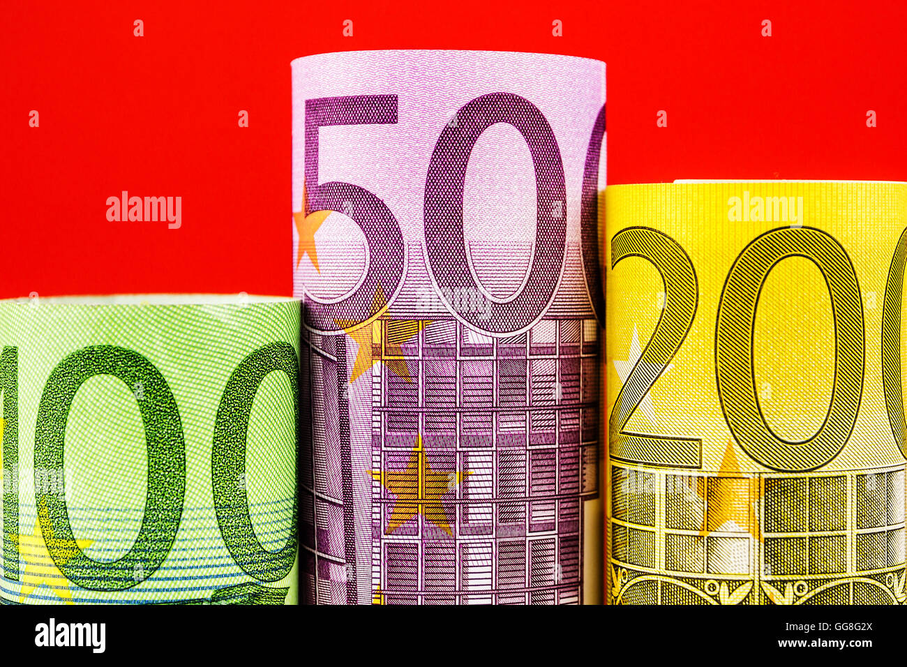 Podio realizzato in tre grandi banconote in euro su sfondo rosso Foto Stock