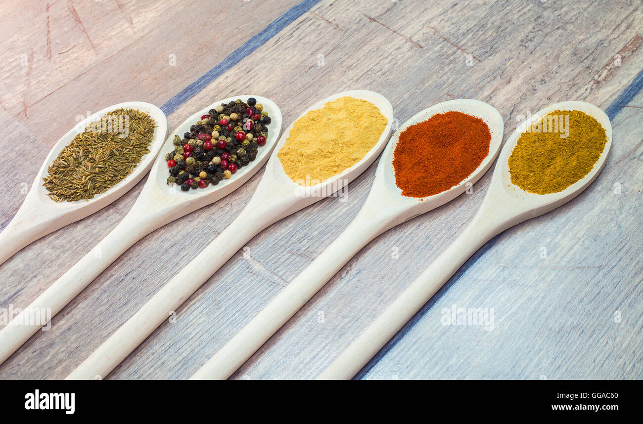 Colore variabile spezie esotiche sul cucchiaio di legno Foto Stock